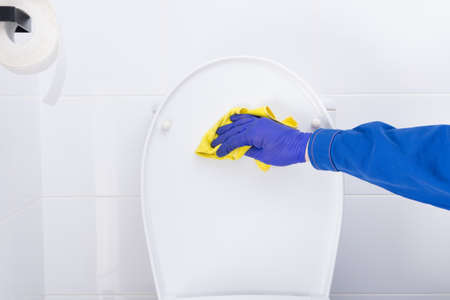 wet cleaning in the toilet room, yellow cloth, hand in a protective gloveの写真素材