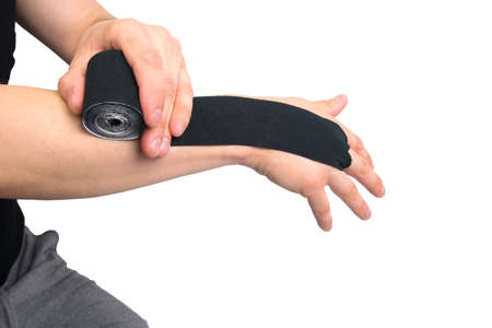 the process of applying the black tape, to protect against injury when playing sportsの写真素材