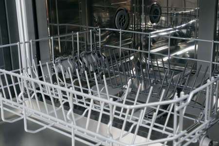 close-up of the inside of a dishwasher with empty nets for kitchen utensilsの写真素材