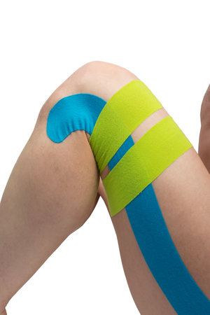 on a white background, a bent leg with kinesio tapes pasted on, to protect against injuries when playing sportsの写真素材