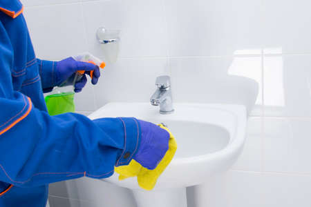 cleaning the bathroom, disinfecting the sink with a cloth and a special toolの写真素材