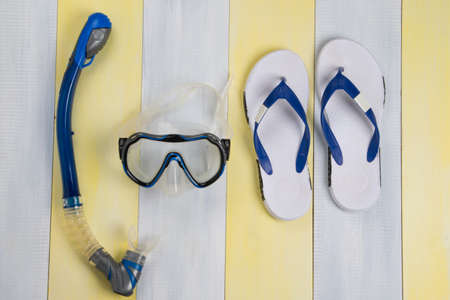 on a striped wooden background, a gray set for swimming in the sea, a mask and slates, diving equipmentの写真素材