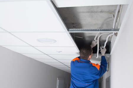 the master has opened the ceiling and understands the intricate wiring of utility networksの写真素材