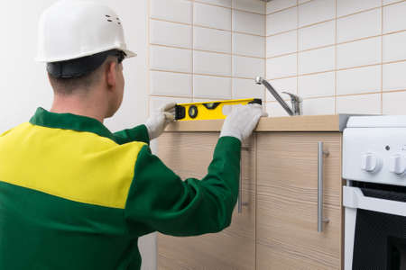 a specialist will check the evenness of the installation of kitchen furniture with a toolの写真素材