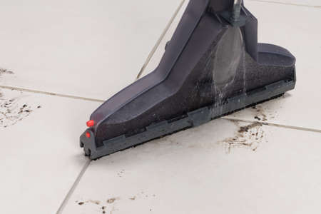 light tile with dirty spots, cleaning with a washing vacuum cleaner, close-upの写真素材