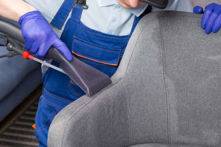 cleaning service worker cleans the drapery of the office chairの写真素材