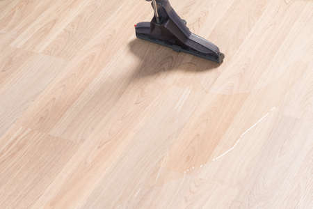 the brush of the washing vacuum cleaner cleans the laminate flooringの写真素材