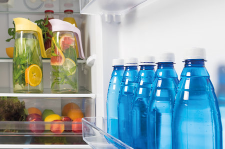 in refrigerators bottled water and lemonade from fresh fruit in decanters, storage of drinks in refrigeratorsの写真素材