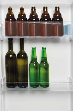 there are bottles of wine and beer in the refrigerator door close-up backgroundの写真素材