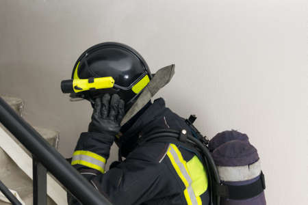 a firefighter in a helmet climbs the stairs, close-upの写真素材