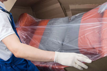 the mover unpacks the upholstered furniture, after deliveryの写真素材