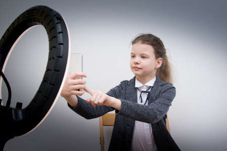 girl blogger, takes a selfie, in front of a ring lampの写真素材