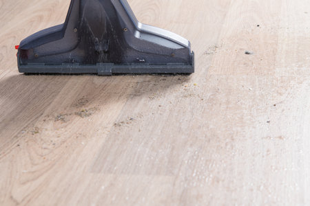 close-up, cleaning with a washing vacuum cleaner on a light laminate with dust, sand and dirt, backgroundの写真素材