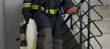 fireman, holding water handling equipment, barrel and hosesの写真素材