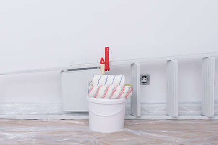 on a white background, building materials, a bucket of paint, rollers and a stepladderの写真素材