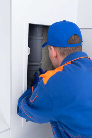 the master carries out repair work of the apartment's communications, rear viewの写真素材