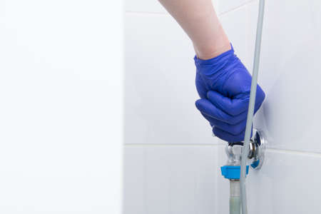 connection to the water supply and sewerage of the washing machine, hand in a protective gloveの写真素材