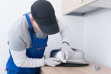 specialist in protective clothing, installs mounting clips to fix the metal sinkの写真素材