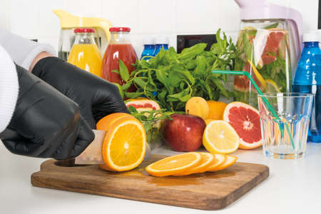 the chef cuts orange wedges for a fruity refreshing smoothieの写真素材