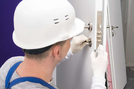 hands in gloves check with the key the operation of the new lock of the front door, rear viewの写真素材