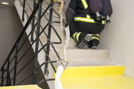 a firefighter with special equipment stretches a line for extinguishingの写真素材