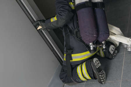 the firefighter locks the door to prevent it from closing during fire extinguishingの写真素材