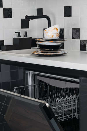 on the table is a stack of dirty dishes for putting in the dishwasher, for cleaningの写真素材