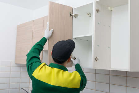 master in the assembly of kitchen furniture, eliminates the guarantee of incorrect operation of door hingesの写真素材