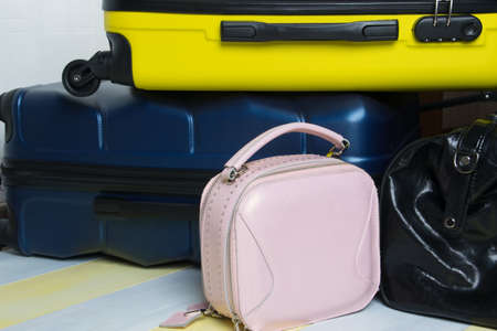 on a yellow-gray background, travel suitcases and a small purse, close-upの写真素材
