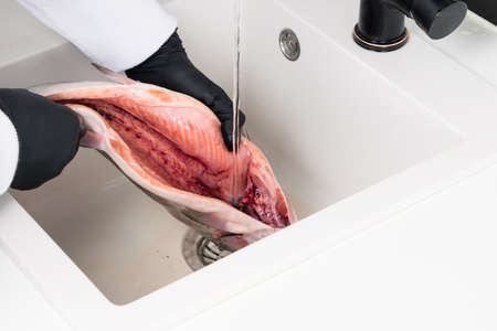hands of the cook after cutting red fish, washed it with waterの写真素材