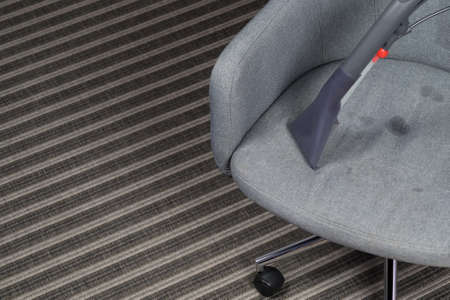the washing vacuum cleaner cleans the upholstery of the office chairの写真素材