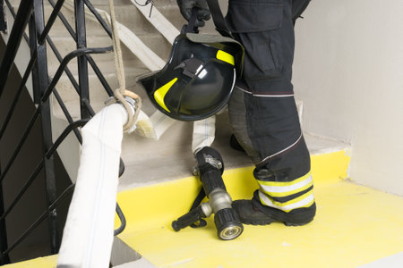 a firefighter holds a helmet in his hands, a close-up view from belowの写真素材