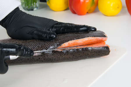 close-up, the chef's hands are cutting up fish for making sushiの写真素材