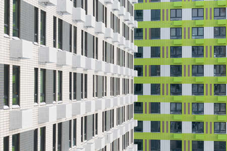 the facade of two houses with white and green baskets for air conditioners, backgroundの写真素材