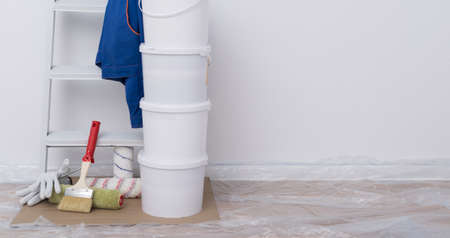 on a white background, building materials, paint buckets, rollers, a stepladder and protective clothing, there is a place for the inscriptionの写真素材