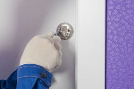 the foreman installs the door locking device, close-upの写真素材