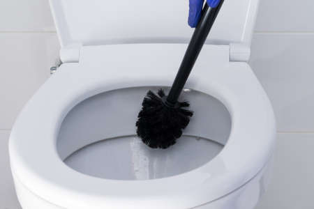 cleaning the toilet bowl with a brush, close-up side viewの写真素材
