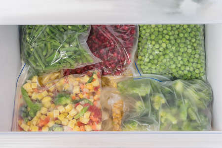 bags of frozen vegetables in the freezer drawerの写真素材