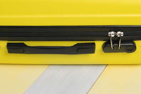 on a yellow gray background a suitcase for travel and a place for your inscription, close-upの写真素材