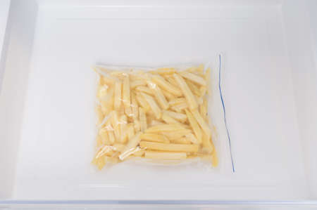 there is a bag of raw French fries in the freezer drawerの写真素材
