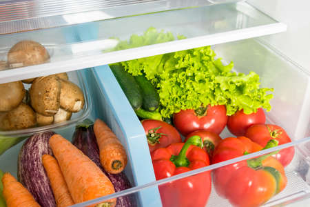 storing vegetables in a refrigerator drawer, close-upの写真素材