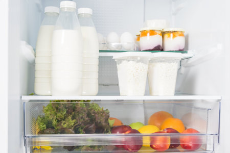 farm dairy products and vegetables on the shelf in the refrigeratorの写真素材