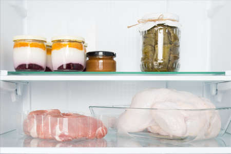 meat and dairy products on the shelf in the refrigerator, front viewの写真素材