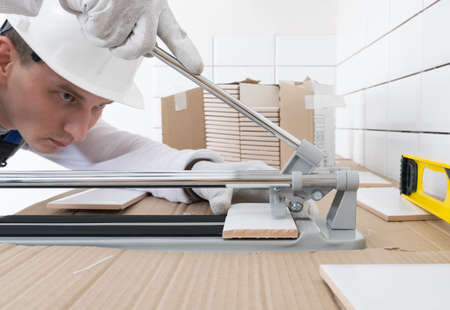 the master of laying ceramics, cuts and breaks the size of the tileの写真素材