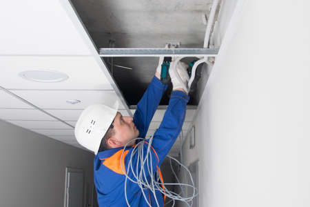 a master for setting up and installing wired Internet, fixes fasteners for cable installationの写真素材