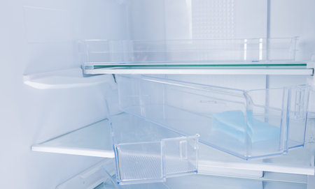 close-up of disassembled shelves and drawers, inside a white refrigeratorの写真素材