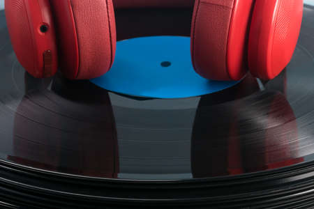 red headphones lie on a black vinyl recordの写真素材