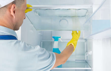 worker disinfects and washes the refrigerator, rear viewの写真素材
