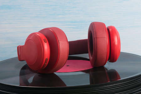 red headphones lie on an old vinyl recordの写真素材
