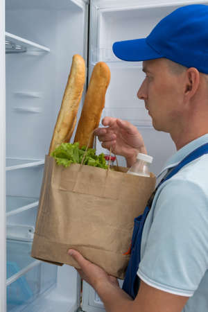 a courier delivered bags of groceries to your refrigeratorの写真素材